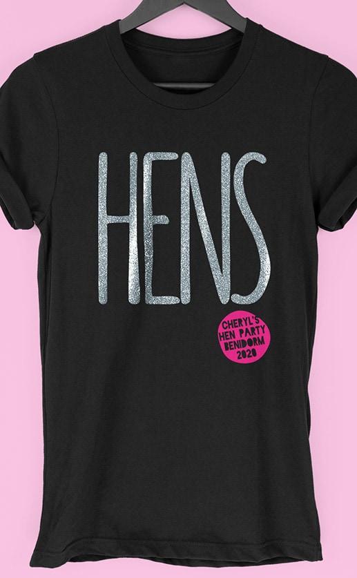 Image to buy product Hens Glitter Personalised Hen Party T Shirt. Large lettering in glitter silver print with subtext in fuchsia on a black t-shirt.