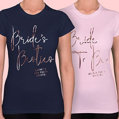 Front shirt example shows Bride's Besties foil design in rose gold print on navy t shirt. Secondary image shows Bride To Be foil design in rose gold on light pink t shirt